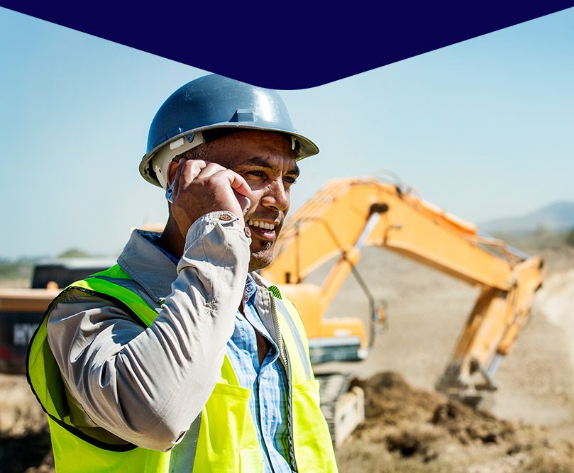 a man talking on a mobile phone in a construction site.